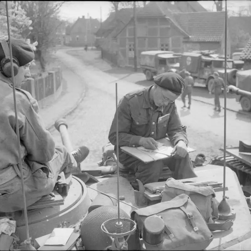 A tank crewman writes a letter home from the turret of his Cromwell tank, April 1945